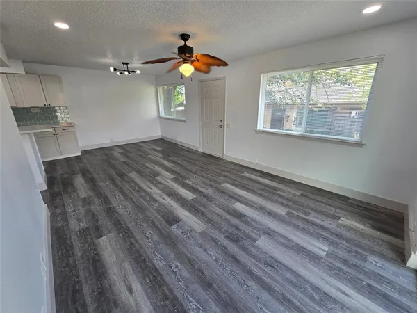 a view of empty room with window and wooden floor
