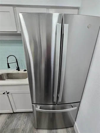a view of kitchen with sink and refrigerator