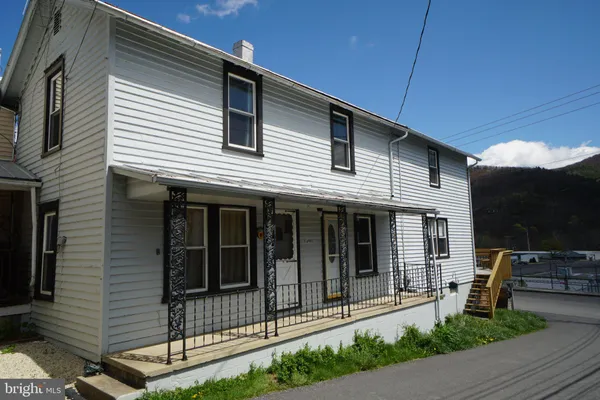 a view of a house with a small yard and wooden floor and fence