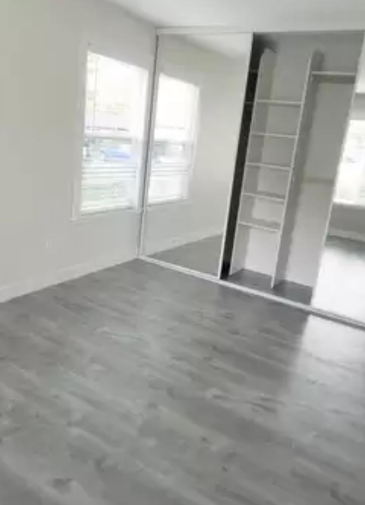 215 Reflections Drive, Unit 15 San Ramon, CA 94583 - Photo 7 of 14 an empty room with wooden floor and windows