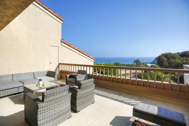 a roof deck with couches and wooden floor