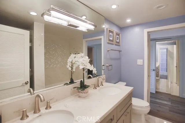 a bathroom with a granite countertop sink a toilet and a mirror