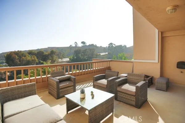 a roof deck with couches and wooden floor