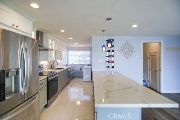 a large kitchen with stainless steel appliances a refrigerator and a sink