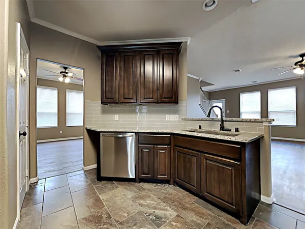 a kitchen with kitchen island granite countertop a sink stove and cabinets