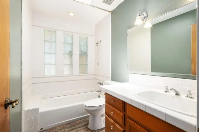 a bathroom with a sink a toilet and shower