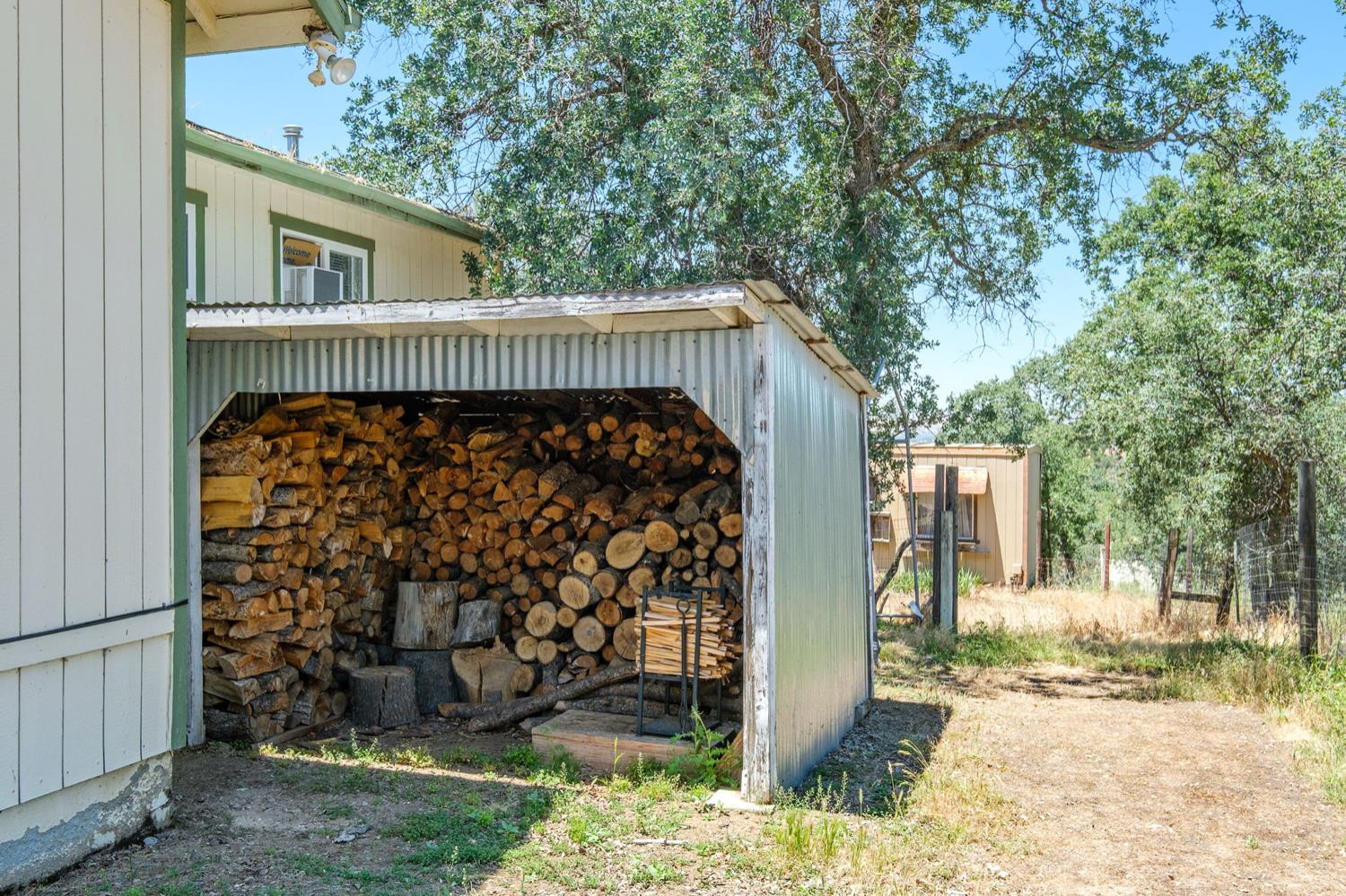 37667 Eagle Drive Raymond, CA 93653 - Photo 33 of 43 a view of a wooden house with large trees and wooden fence