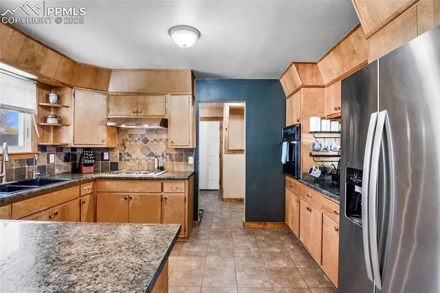 a kitchen with stainless steel appliances granite countertop a refrigerator and a sink