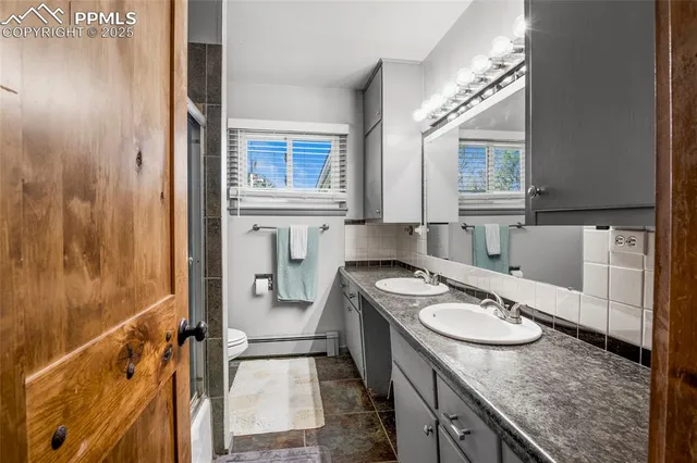 a bathroom with a granite countertop sink a mirror and shower