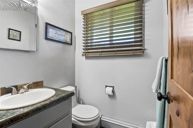 a bathroom with a granite countertop toilet a sink and a mirror