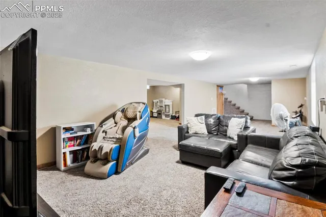 a living room with furniture a flat screen tv and a table