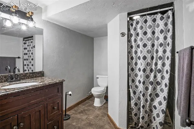 a bathroom with a granite countertop sink a toilet and a mirror