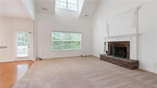 an empty room with windows and fireplace