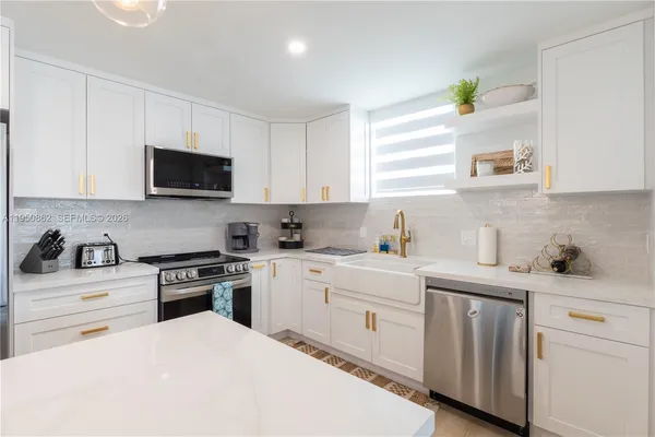 a kitchen with stainless steel appliances white cabinets and a stove