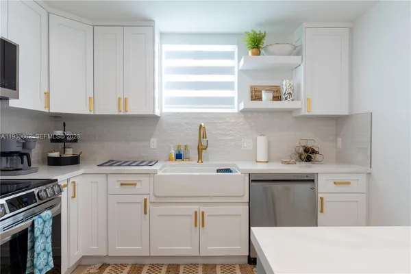a kitchen that has a sink cabinets and stainless steel appliances