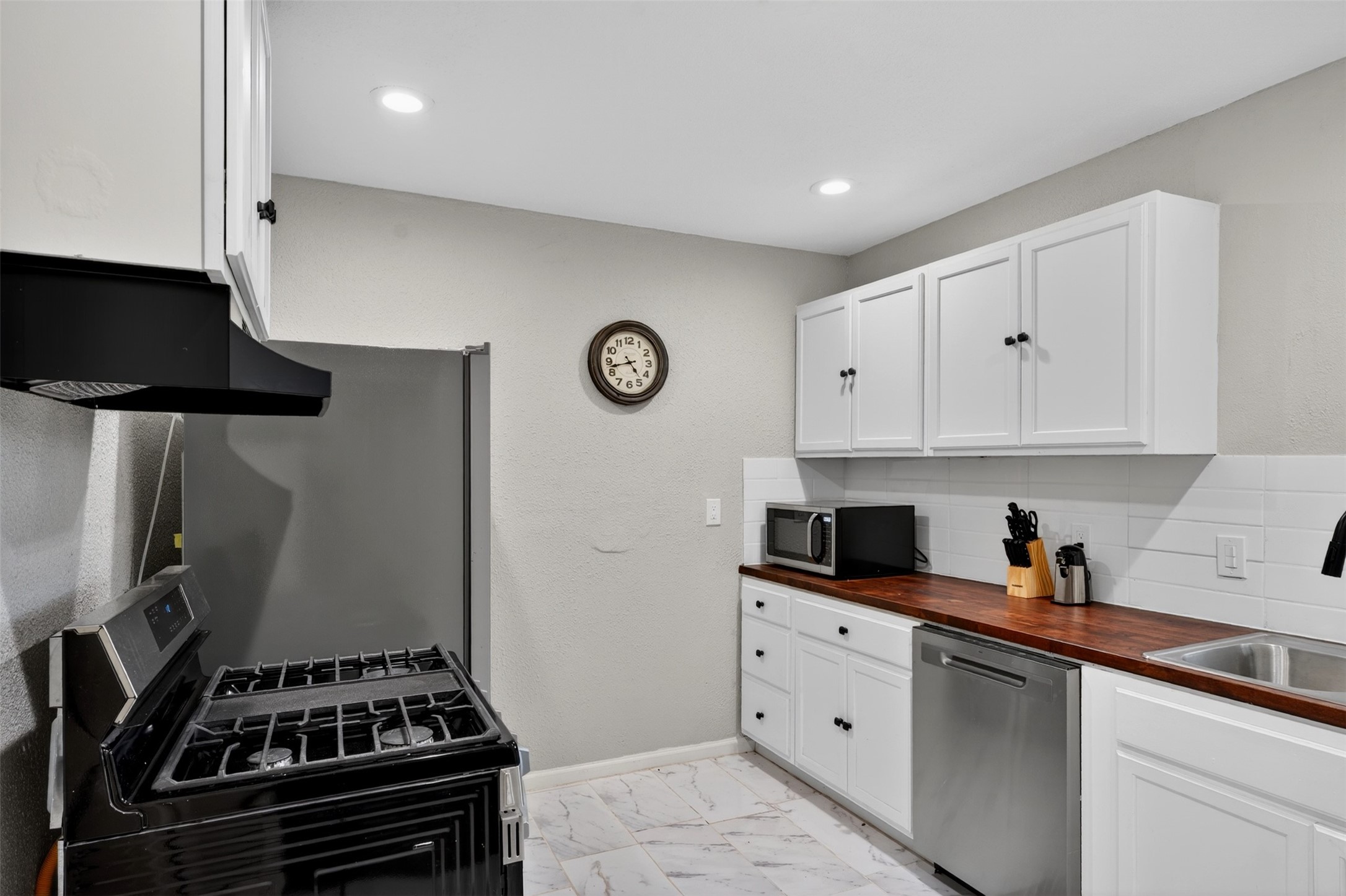 3863 Arbor Street Houston, TX 77004 - Photo 23 of 35 a kitchen with white cabinets and appliances