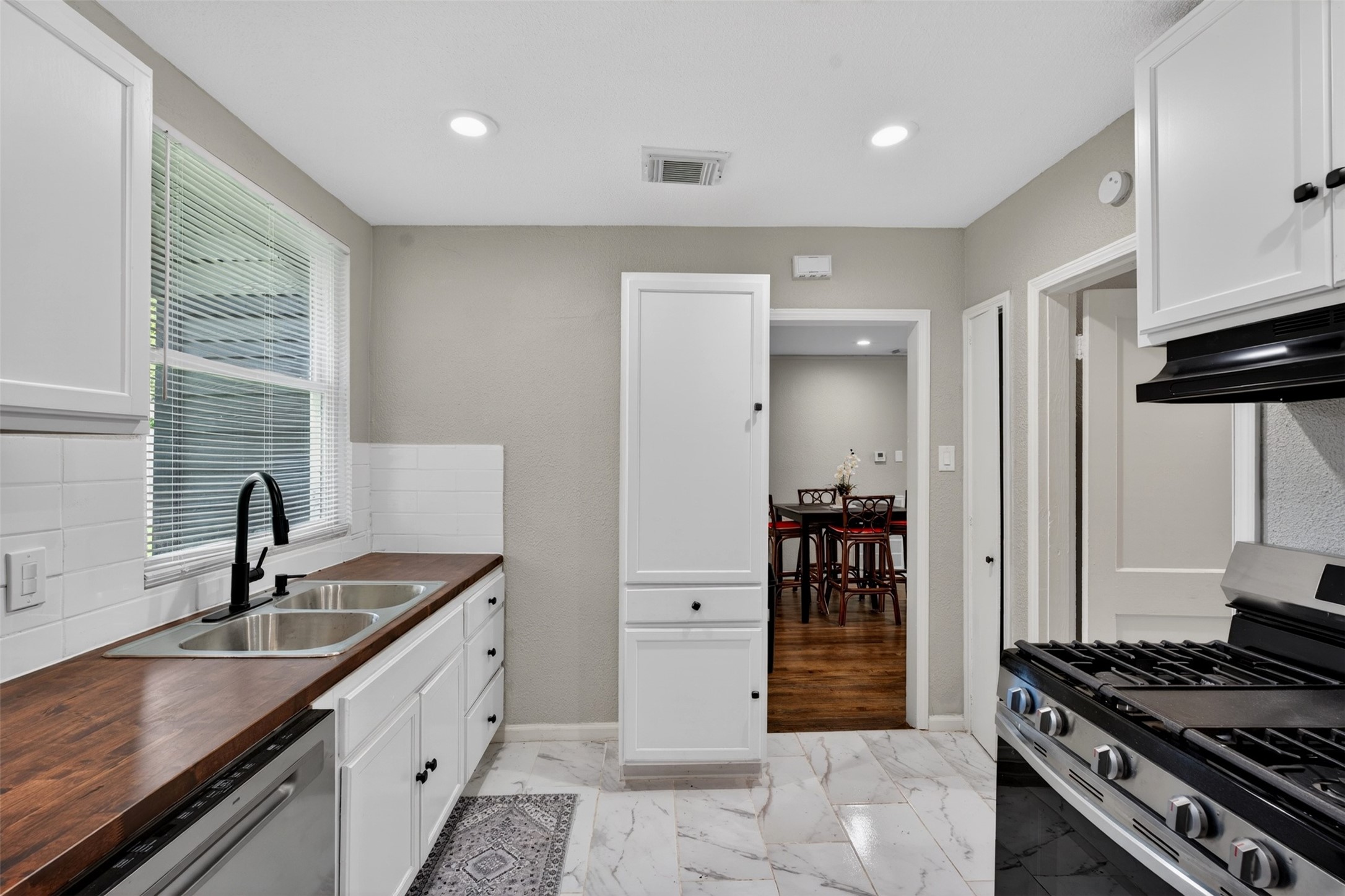 3863 Arbor Street Houston, TX 77004 - Photo 26 of 35 a kitchen with kitchen island a counter space a sink and a stove