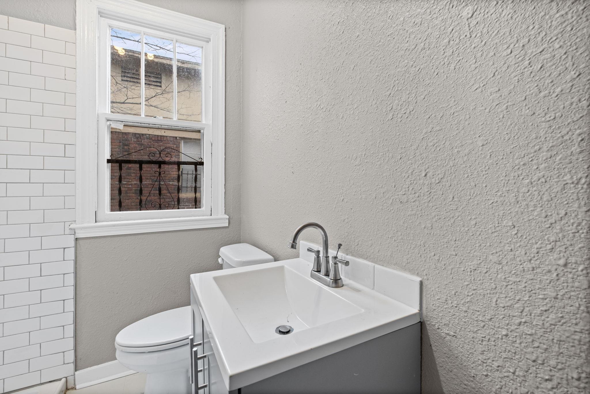 1503 Swift Street Memphis, TN 38109 - Photo 2 of 17 a bathroom with a sink a toilet and a window