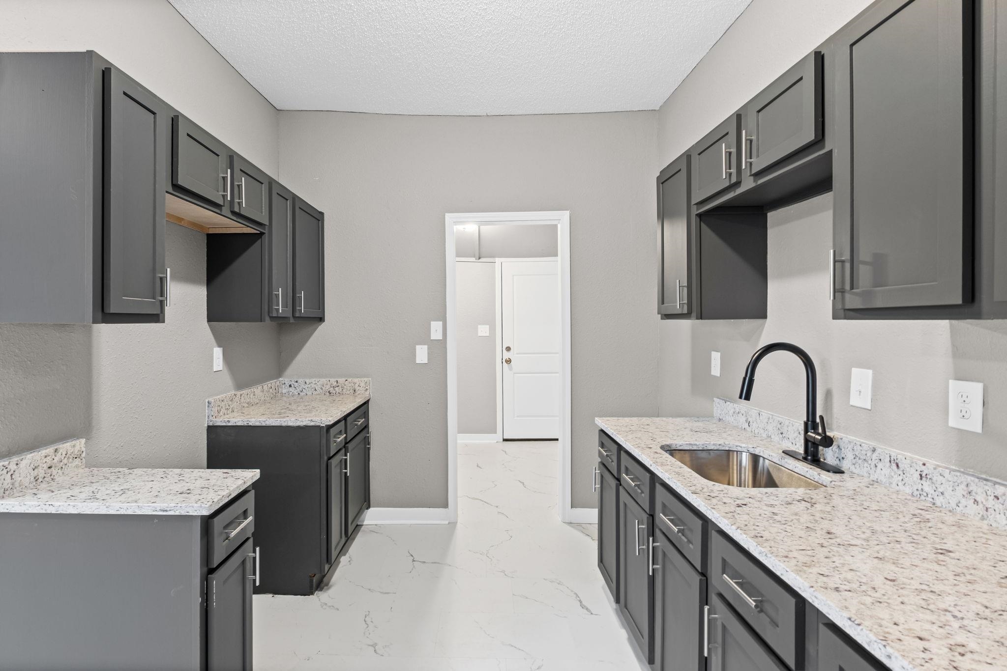 1503 Swift Street Memphis, TN 38109 - Photo 8 of 17 a kitchen with granite countertop a sink a stove and refrigerator