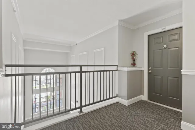 a view of a hallway with wooden floor and a bathroom