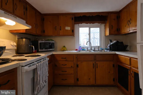 a kitchen with stainless steel appliances a stove a sink and a microwave
