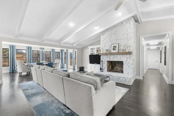 a living room with furniture wooden floor and a flat screen tv