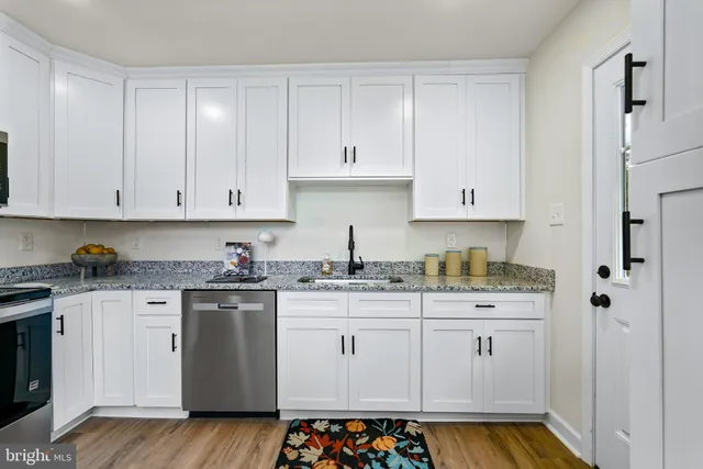 a kitchen with stainless steel appliances granite countertop a sink stove and cabinets