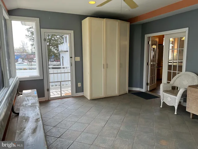 a view of an empty room with wooden floor fireplace and a window