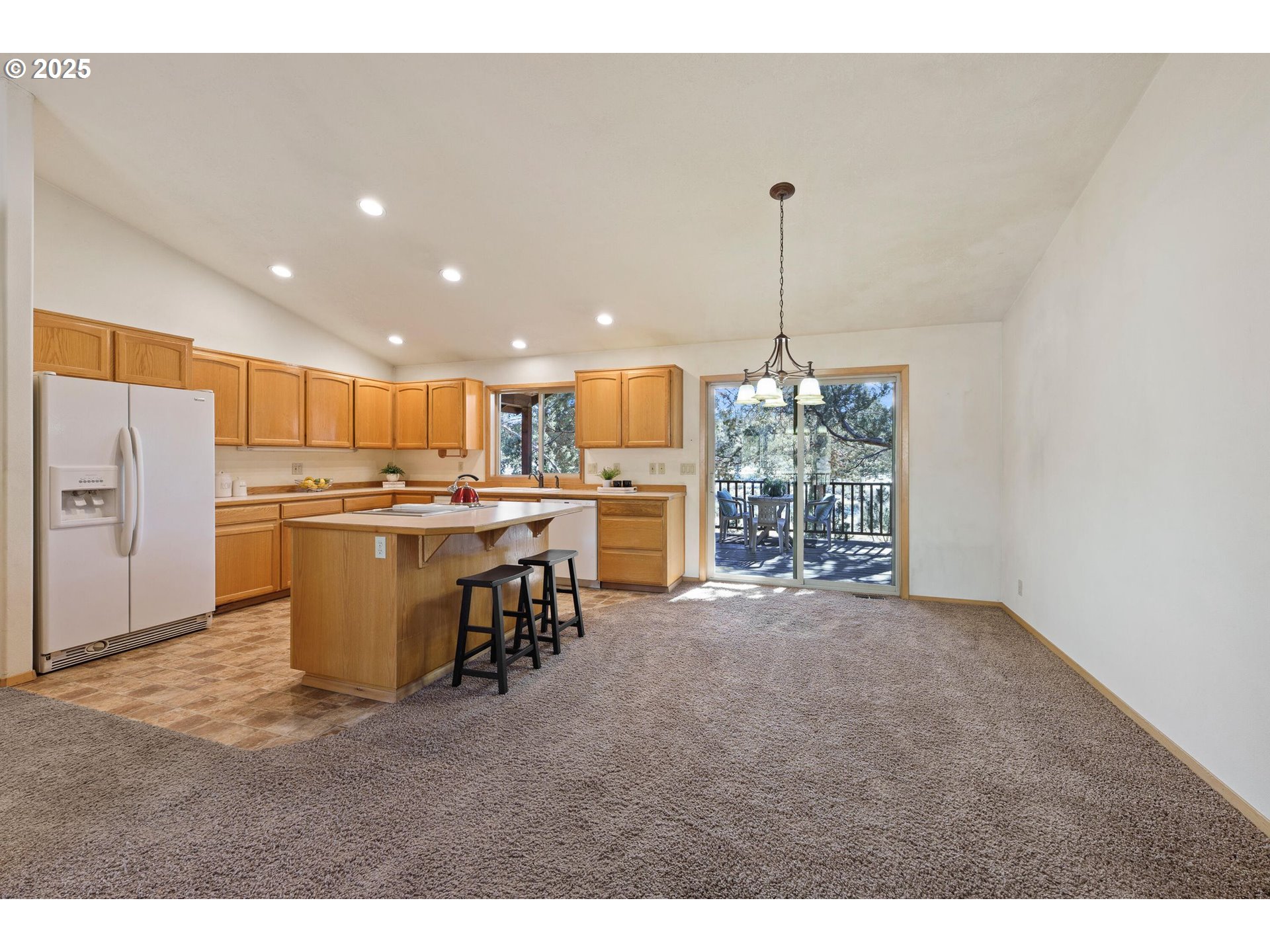 64520 Joe Neil Road Bend, OR 97701 - Photo 17 of 40 a open kitchen with a refrigerator a stove top oven a sink and a island