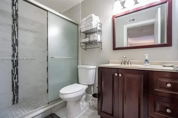 a bathroom with a toilet a sink a shower and mirror