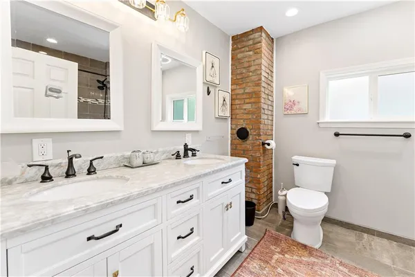a bathroom with a granite countertop toilet sink and a mirror