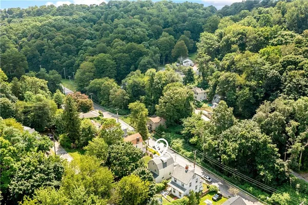 an aerial view of a residential houses with yard and flowers