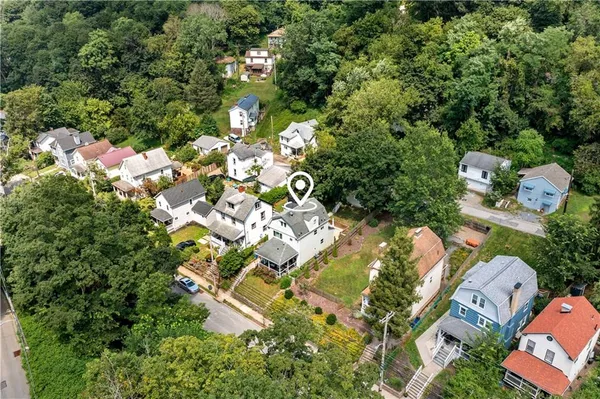 an aerial view of residential house with outdoor space and trees all around