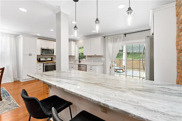 a kitchen with stainless steel appliances granite countertop a stove top oven a sink and a refrigerator