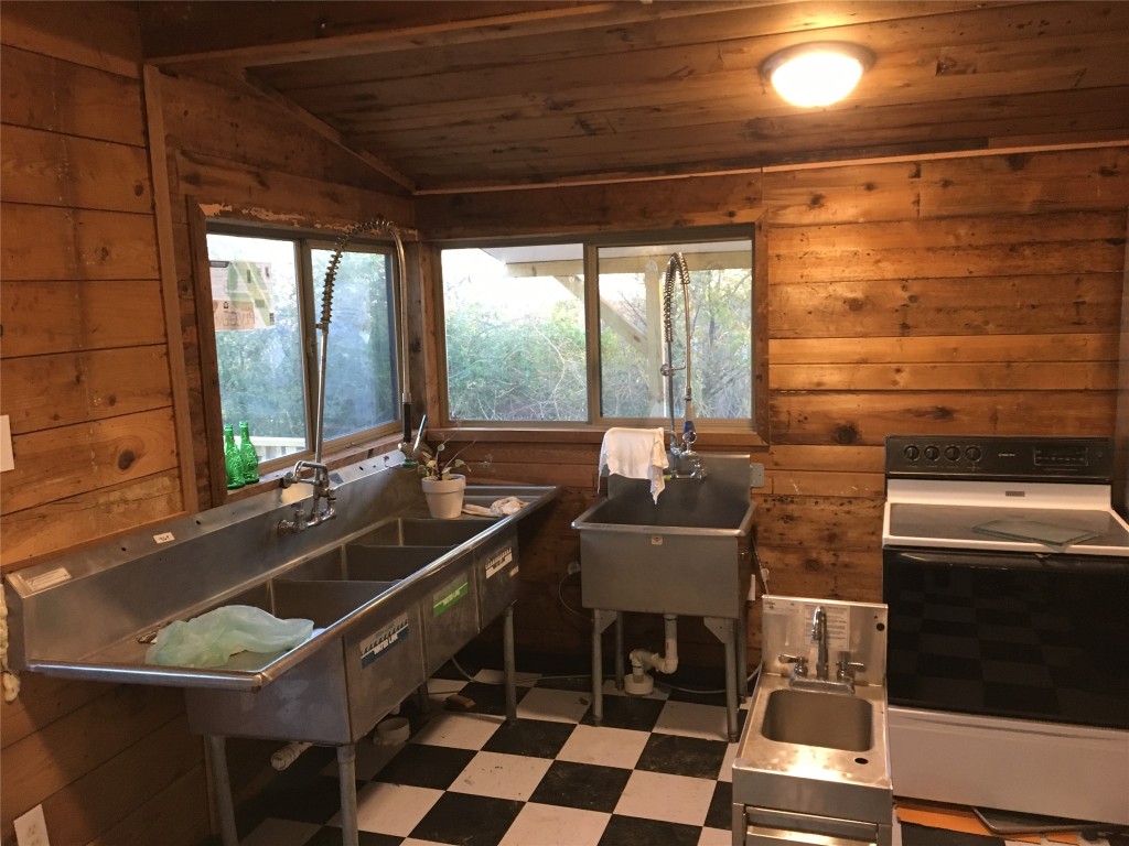 Undisclosed Address Niederwald, TX 78640 - Photo 2 of 10 a kitchen with a sink a counter and chairs