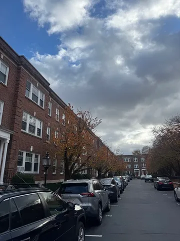 a city street lined with cars parked in front of it