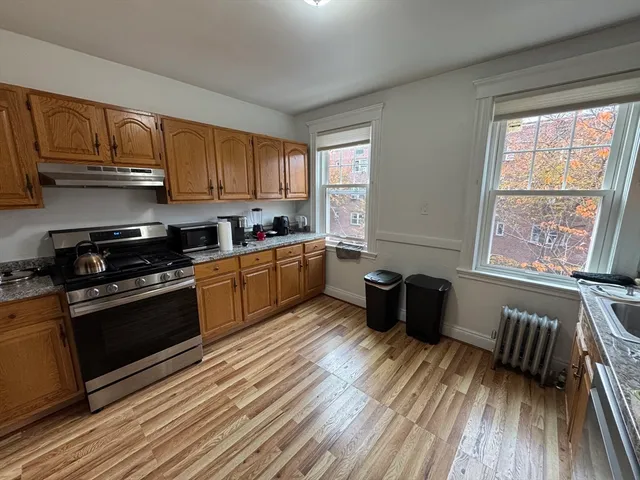 a kitchen with wooden floors and black appliances
