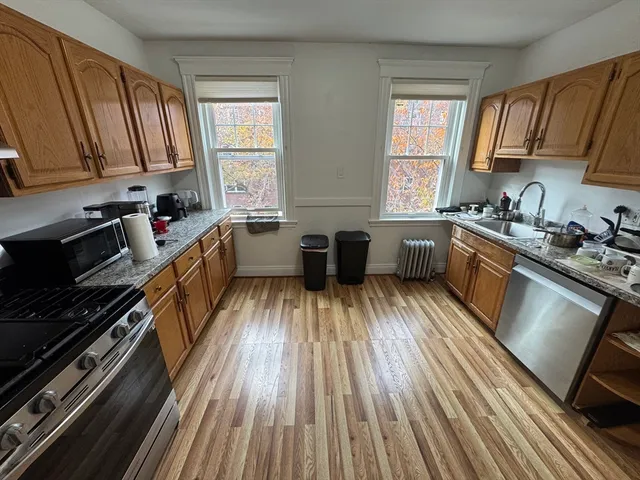 a kitchen with wooden floors and stainless steel appliances