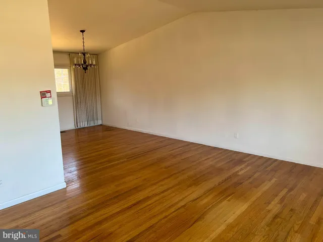 a view of a room with wooden floor and a ceiling fan