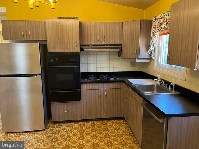 a kitchen with kitchen island a counter top space cabinets and stainless steel appliances
