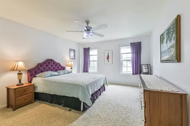 a spacious bedroom with a large bed and a chandelier