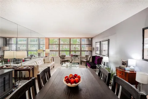 a living room with furniture a chandelier and a large window