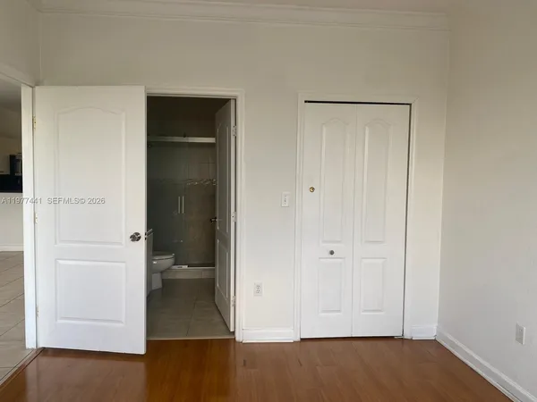 an empty room with wooden floor and closet