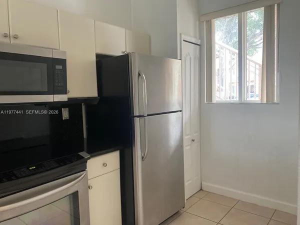 a kitchen with metallic refrigerator and microwave