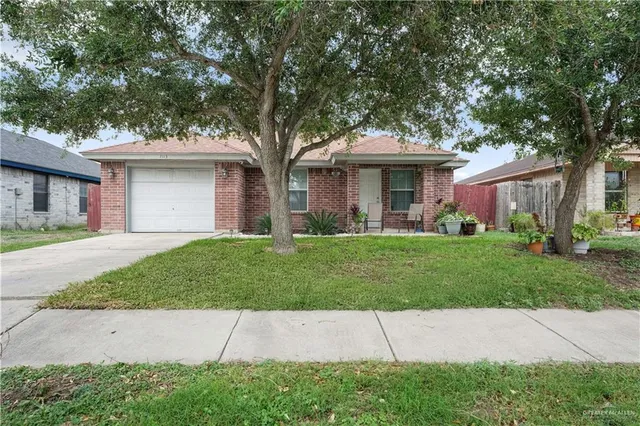 a front view of a house with a garden and yard
