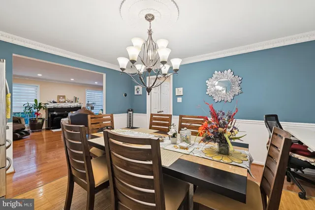 a dining room filled chandelier and kitchen view