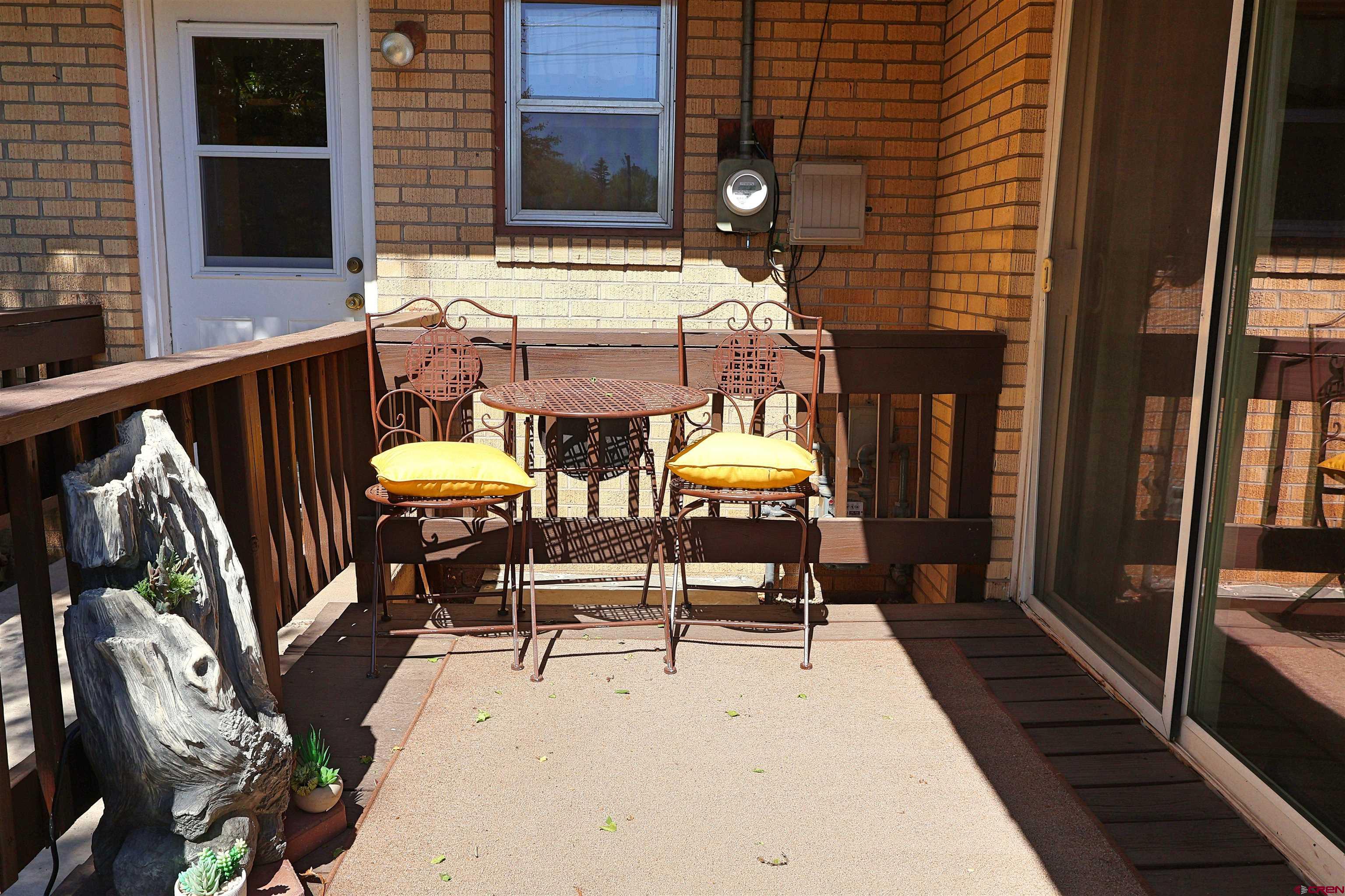 96 El Rio Drive Alamosa, CO 81101 - Photo 15 of 18 a view of a patio with table and chairs with wooden floor and fence