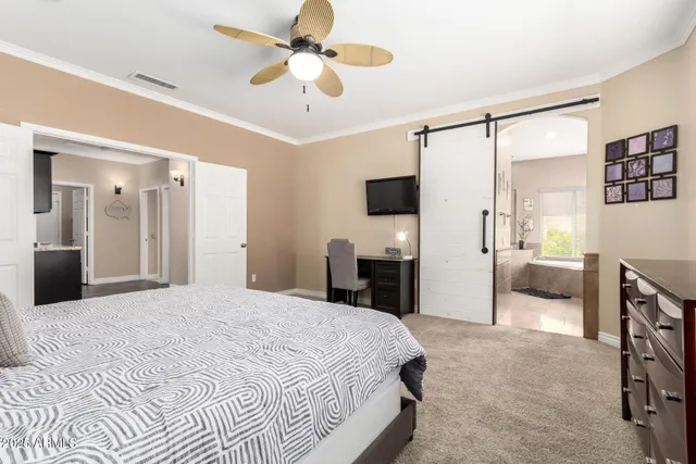 a bedroom with a bed flat screen tv and a chandelier