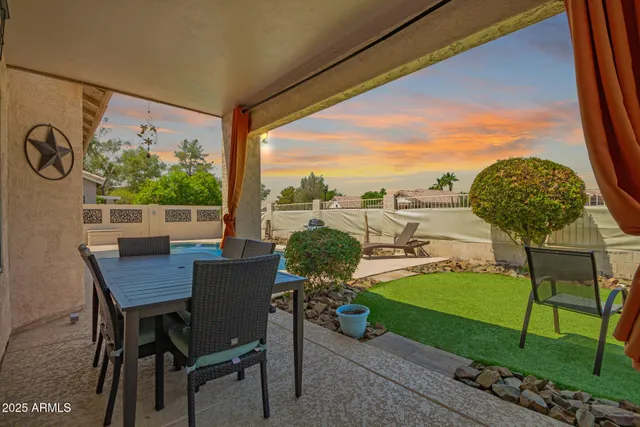 a view of a house with a backyard and sitting area