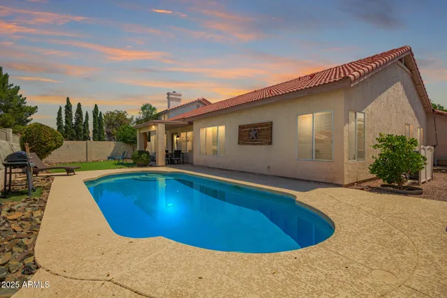 a backyard of a house with table and chairs